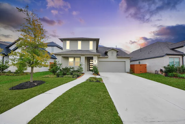 a front view of a house with a yard and garage