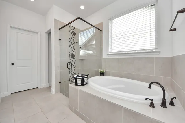 a bathroom with a tub a sink and a window