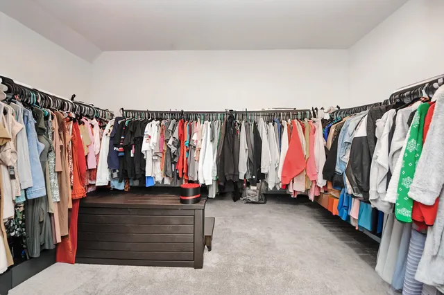 a view of walk in closet with clothes