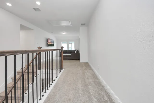 a view of a hallway with wooden floor and windows