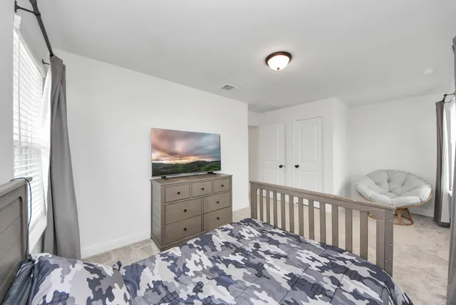 a room with a bed and a television