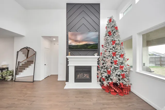 a living room with a fireplace furniture and a christmas tree