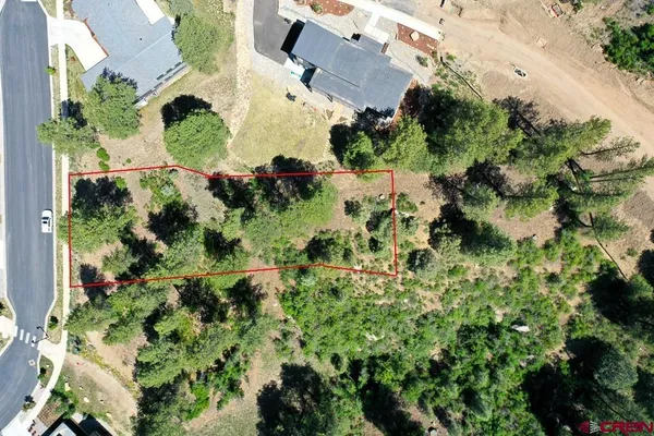an aerial view of residential house with outdoor space and trees all around