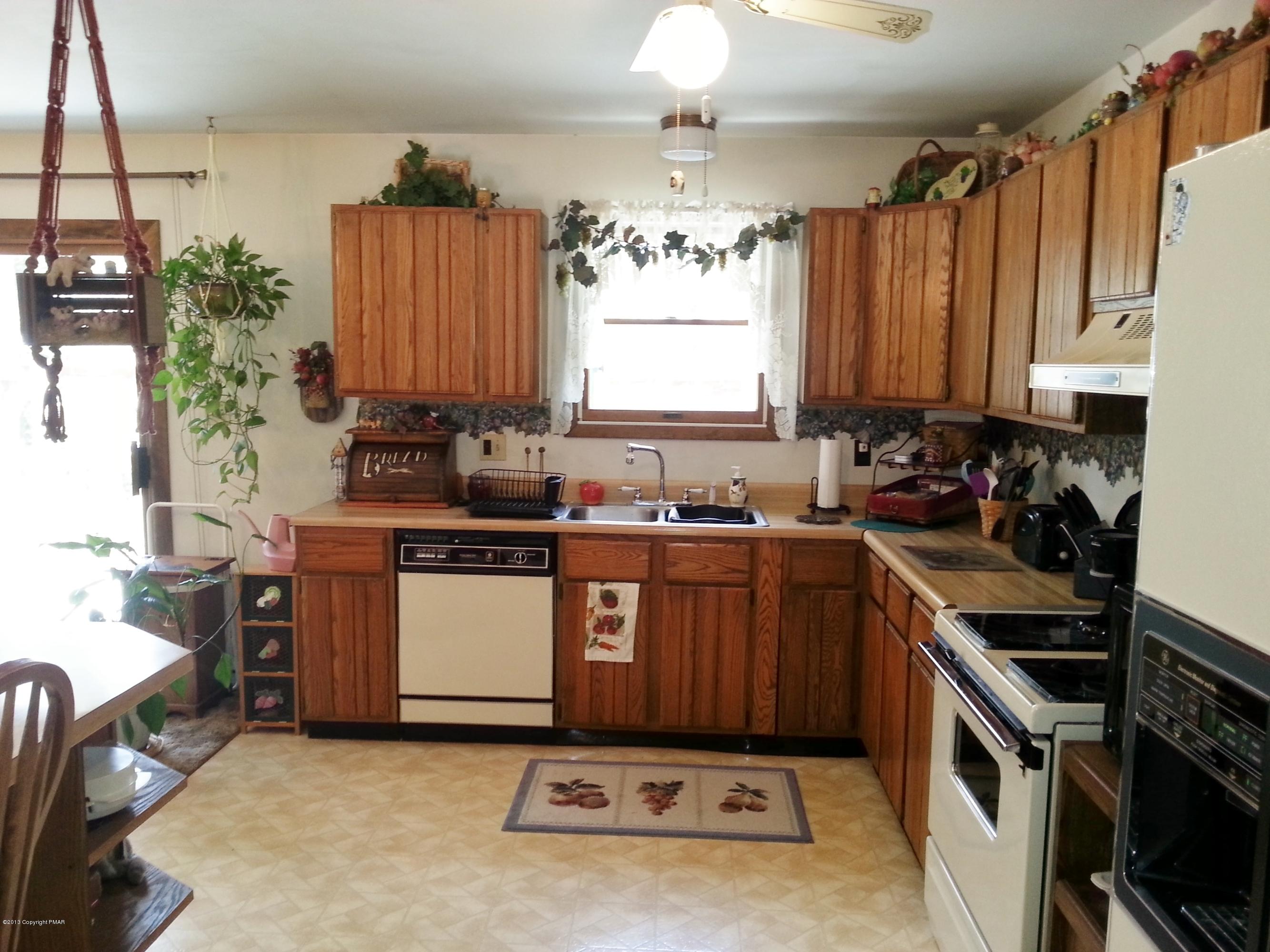 2187 Shafer Road Stroudsburg, PA 18360 - Photo 6 of 29 a kitchen with a stove a sink a microwave a refrigerator and cabinets