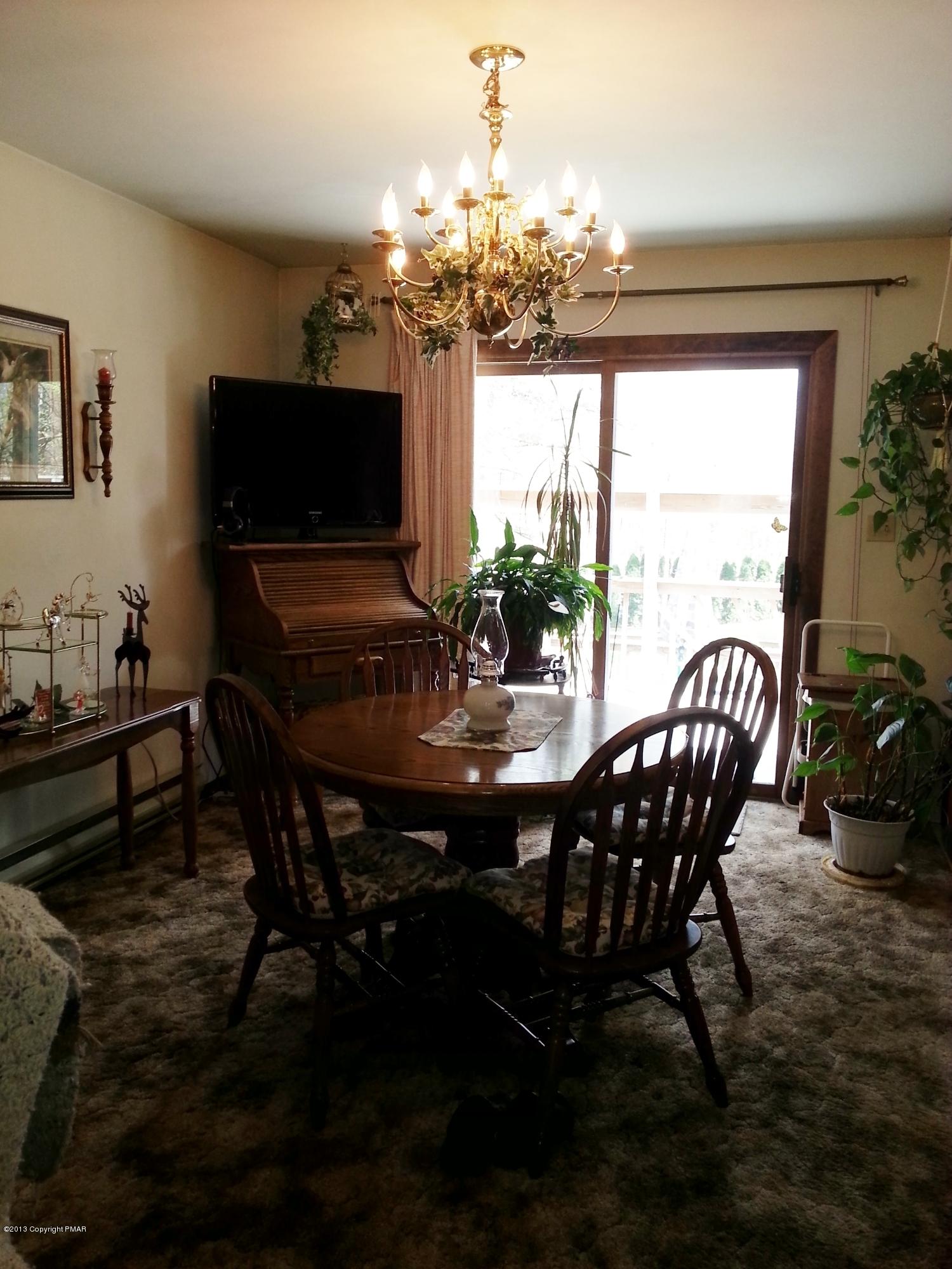 2187 Shafer Road Stroudsburg, PA 18360 - Photo 8 of 29 a view of a dining room with furniture a chandelier and large window