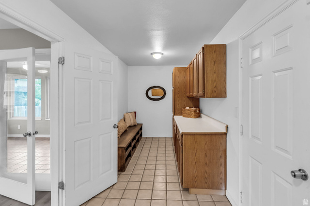 1539 East 450 South Springville, UT 84663 - Photo 19 of 49 Mudroom featuring extensive wood-finish cabinetry, light-toned countertop, and square tile flooring