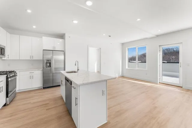 a kitchen with stainless steel appliances granite countertop a refrigerator and a sink