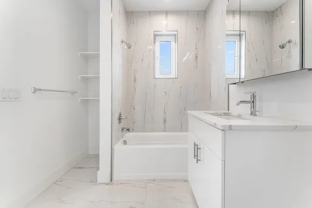 a bathroom with a bathtub sink and mirror