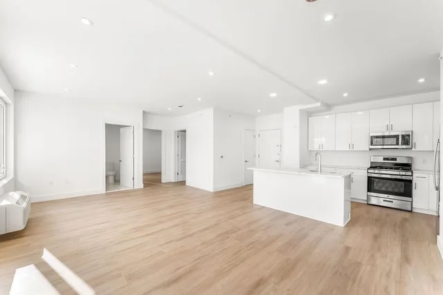 a view of kitchen with wooden floor and electronic appliances