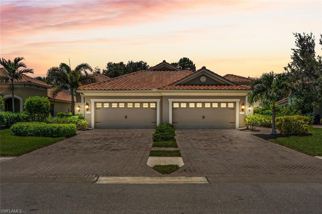 4565 Waterscape Lane Fort Myers, FL 33966 - Photo 3 of 42 Mediterranean / spanish-style home with stucco siding, decorative driveway, a tiled roof, and an attached garage
