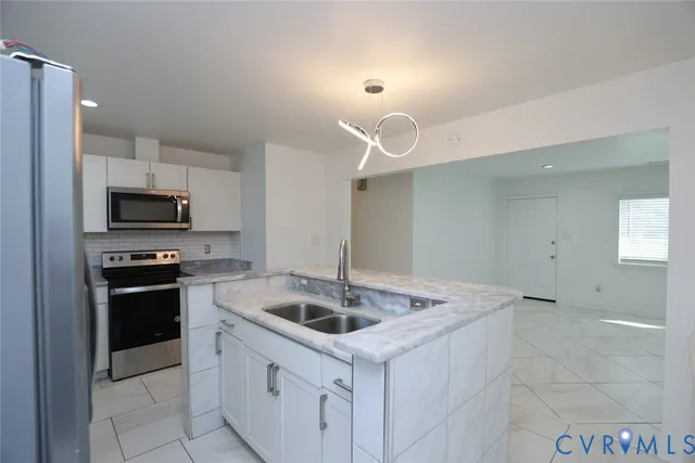 a kitchen with granite countertop a sink and refrigerator