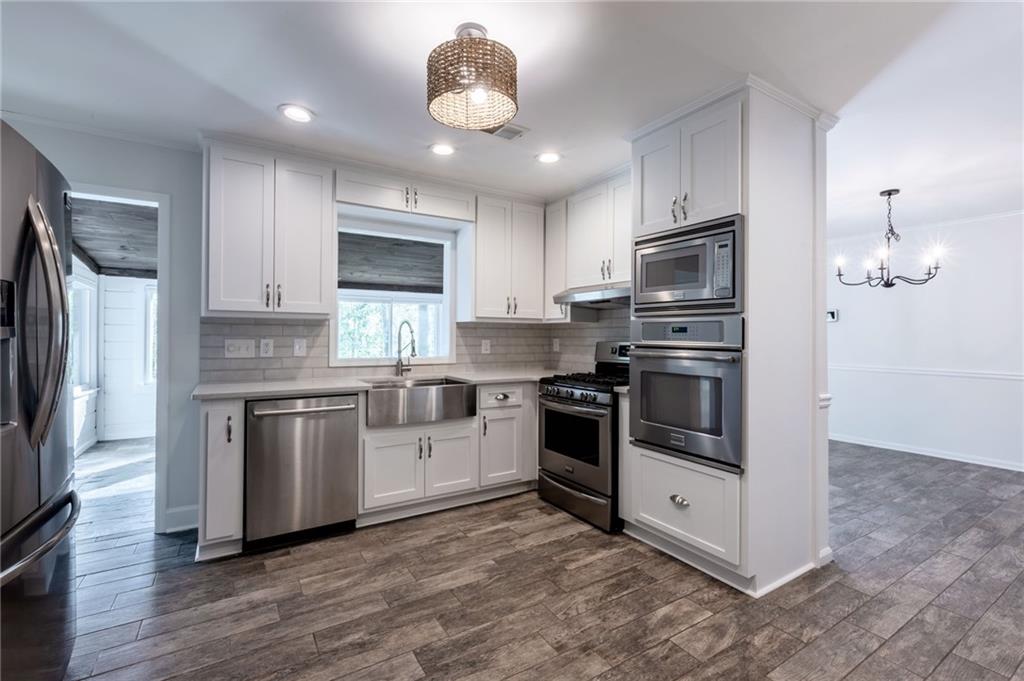 143 Swanson Road Fayetteville, GA 30214 - Photo 6 of 27 a kitchen with granite countertop a refrigerator stove and microwave