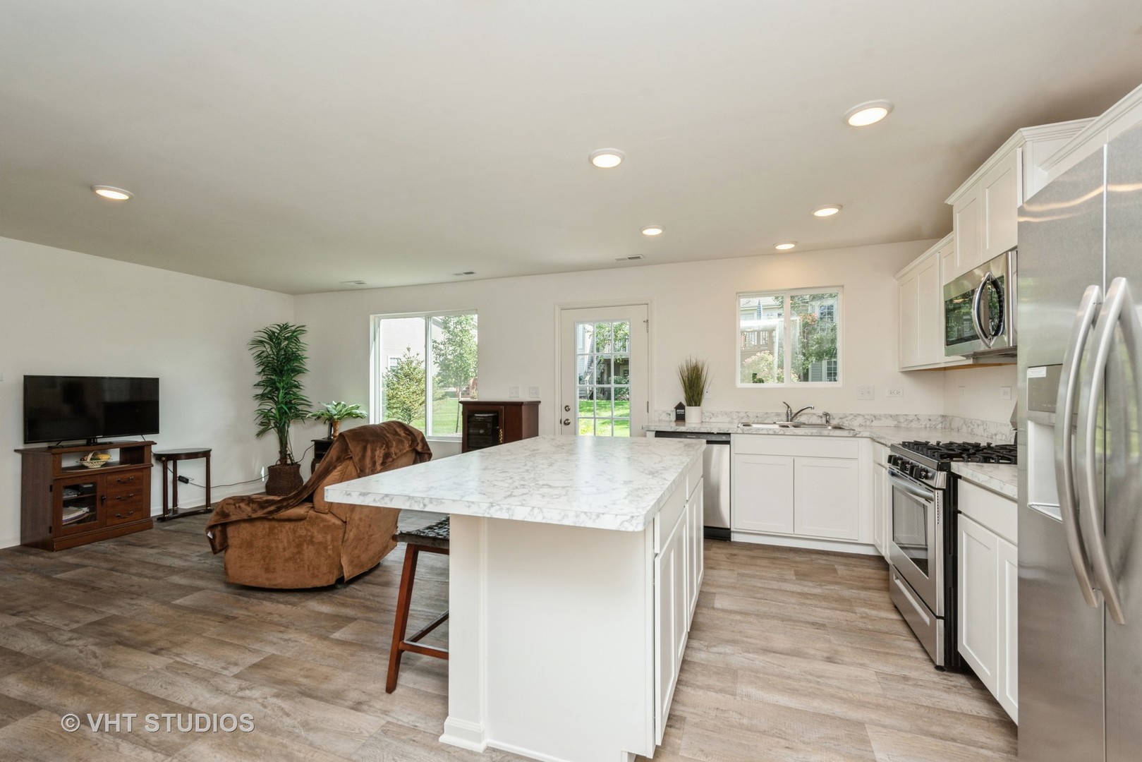 1205 Prairie View Parkway Cary, IL 60013 - Photo 4 of 14 a open kitchen with stainless steel appliances granite countertop a stove top oven a sink dishwasher a dining table and chairs with wooden floor