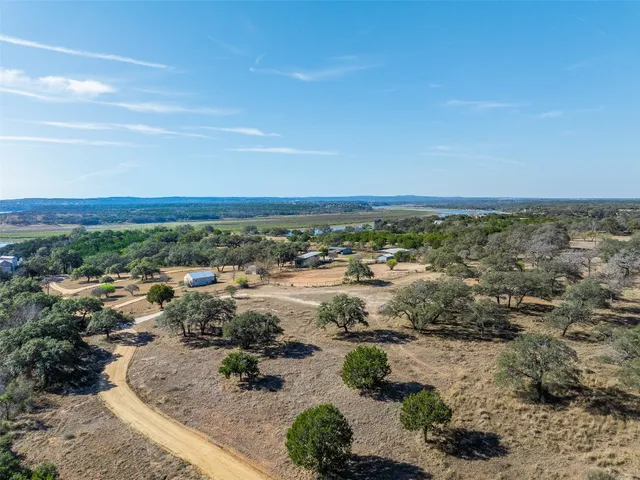 an aerial view of residential house with outdoor space and trees all around