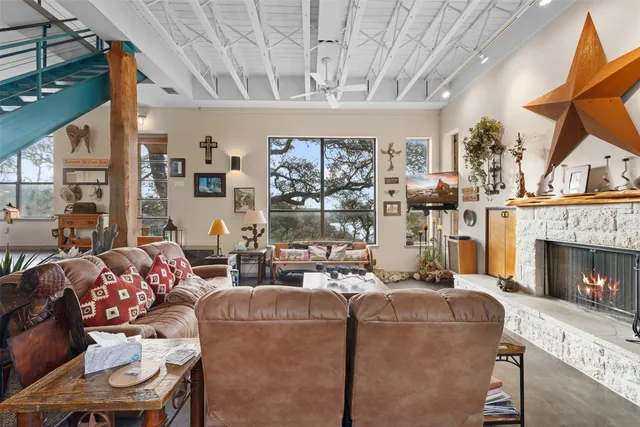 a living room with furniture a fireplace and a floor to ceiling window