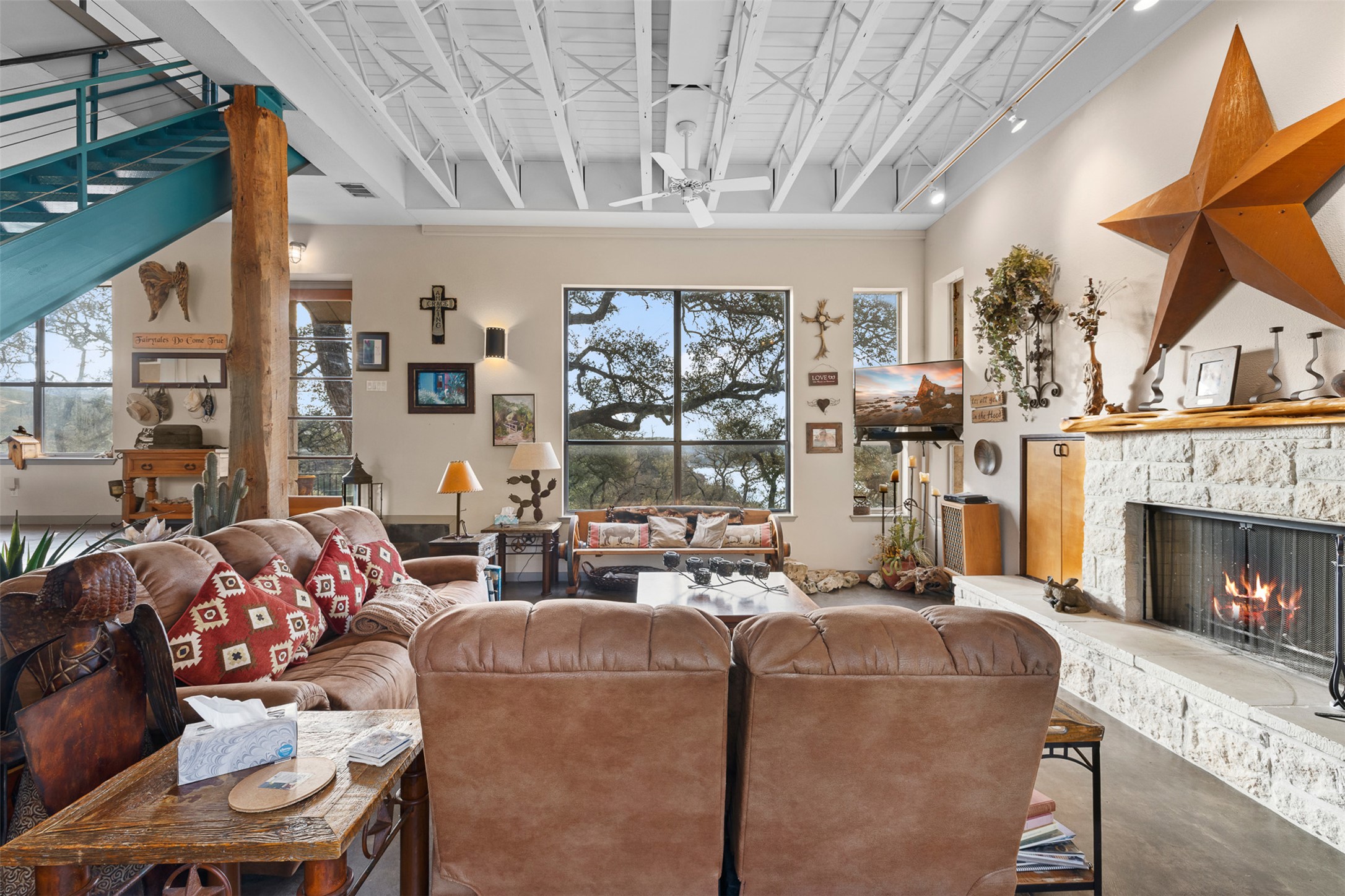 27701 Turner Ranch Road Marble Falls, TX 78654 - Photo 6 of 40 a living room with furniture a fireplace and a floor to ceiling window