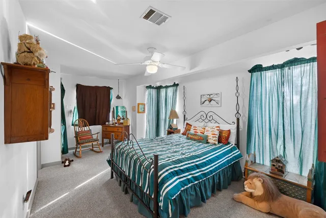 a bedroom with bed and large windows