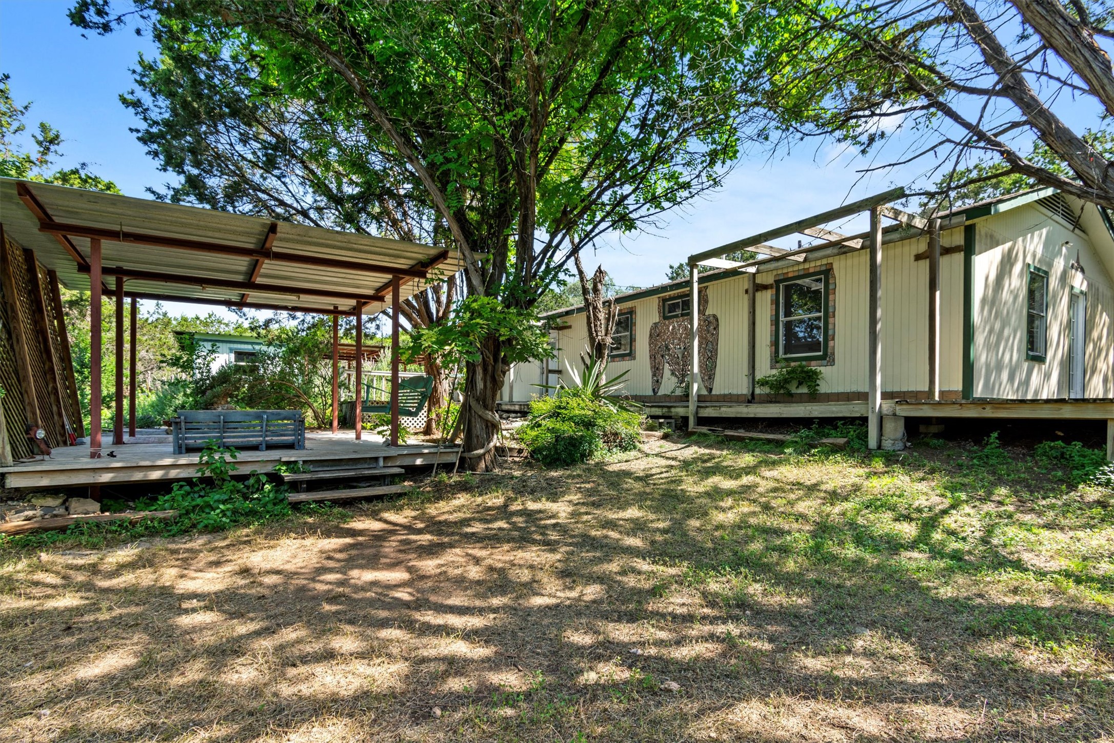 6 El Sol Road Wimberley, TX 78676 - Photo 20 of 20 A quaint residence sits amid established greenery, featuring a welcoming covered porch.