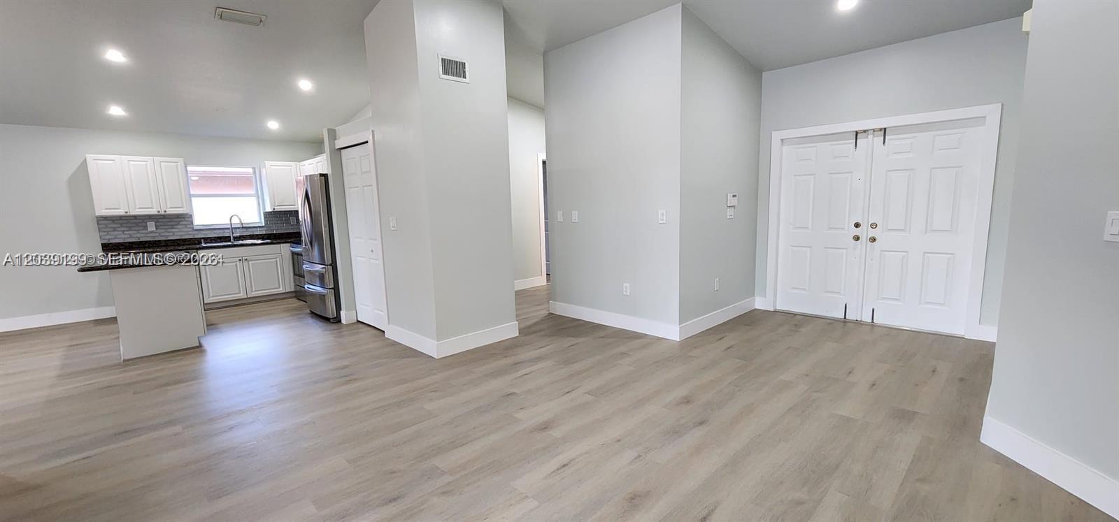 14817 Southwest 180th Street Miami, FL 33187 - Photo 2 of 15 a view of a kitchen with a stove cabinets and wooden floor