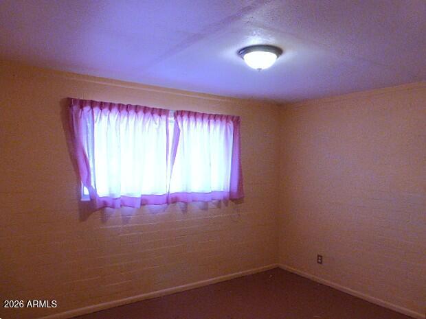303 Greenwich Road Kearny, AZ 85137 - Photo 8 of 18 an empty room with wooden floor and windows