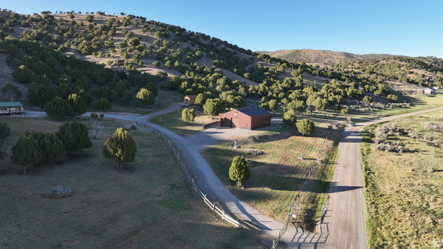 2006 Swenson Valley Road Bancroft, ID 83217 - Photo 48 of 51 Expansive property featuring multiple structures, including a brown barn-style building and a single-story residence with a covered porch