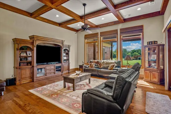 a living room with furniture a flat screen tv and a floor to ceiling window