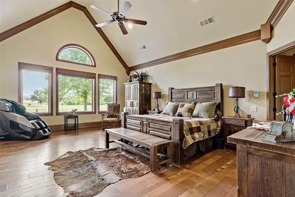 a spacious bedroom with a bed a couch and dresser