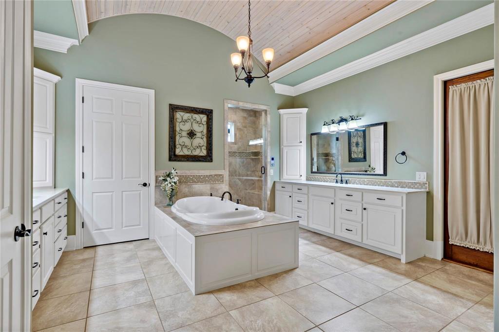 695 County Rd Road Honey Grove, TX 75446 - Photo 17 of 40 a spacious bathroom with a double vanity sink a mirror a bathtub and a window