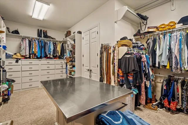 a view of walk in closet with clothes and shoes