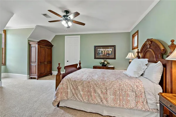 a bedroom with a bed and a ceiling fan