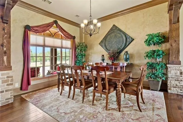 a view of a dining room and livingroom with furniture wooden floor a chandelier