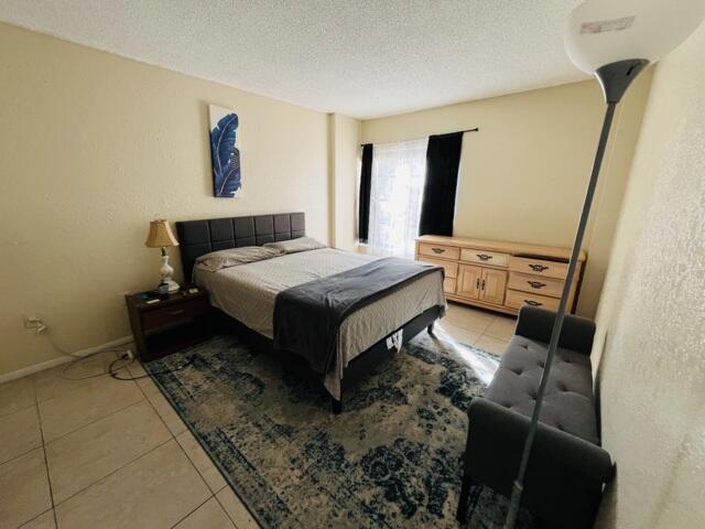 4160 Inverrary Drive, Unit 207 Lauderhill, FL 33319 - Photo 7 of 13 a spacious bedroom with a bed and wooden floor