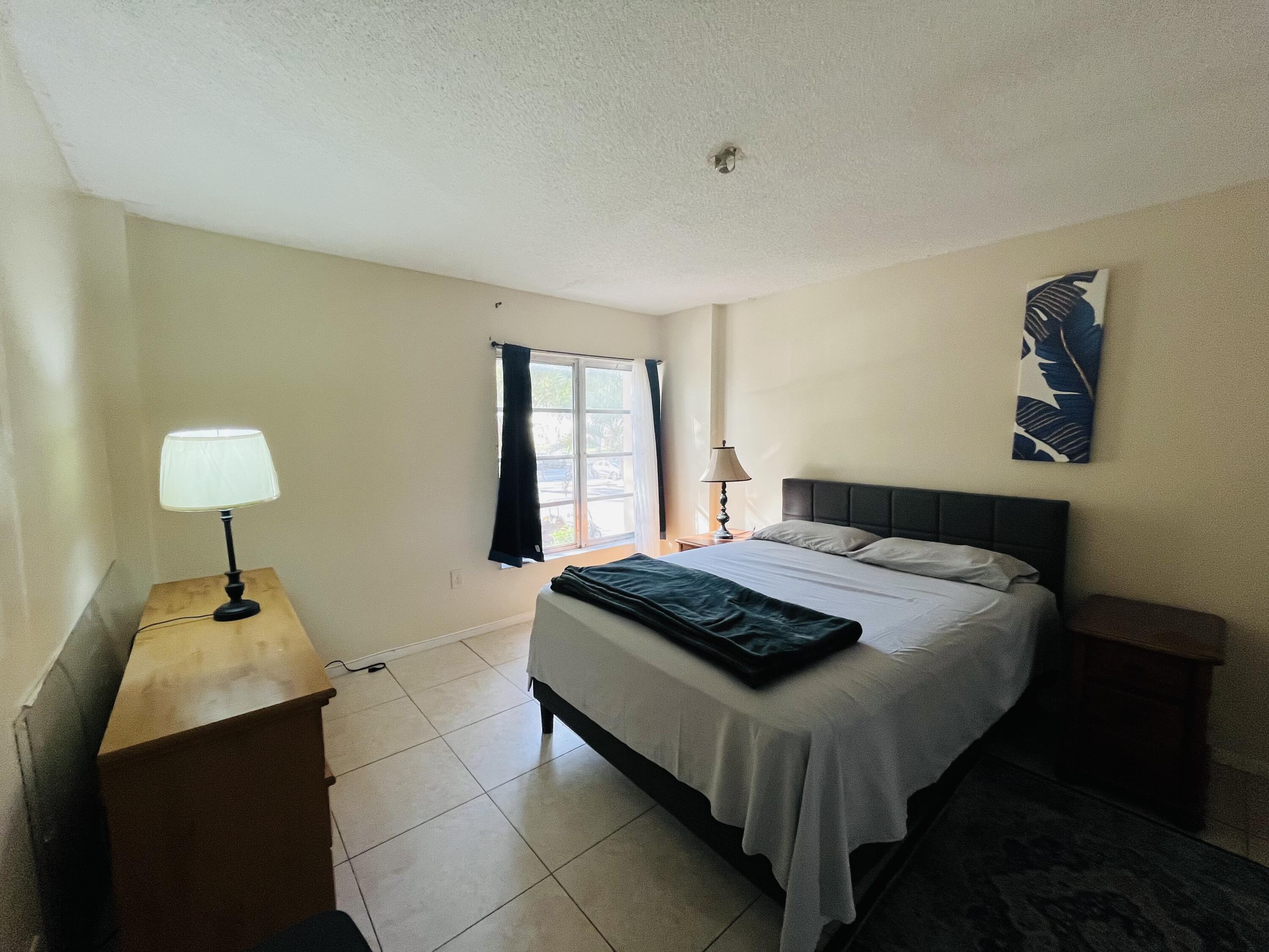 4160 Inverrary Drive, Unit 207 Lauderhill, FL 33319 - Photo 10 of 13 a bedroom with a bed and a chandelier