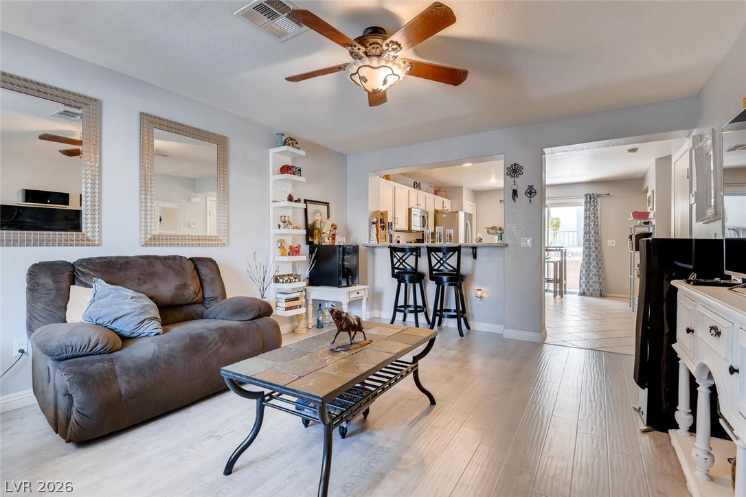 10451 Processor Court Las Vegas, NV 89129 - Photo 6 of 28 An inviting open-concept living area with a breakfast bar, perfect for casual entertaining.
