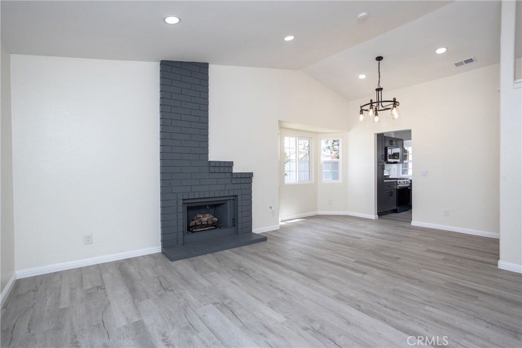 45800 Classic Way Temecula, CA 92592 - Photo 11 of 61 an empty room with wooden floor fireplace and windows