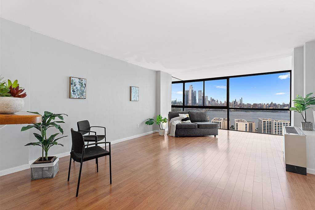 380 Mountain Road, Unit 907 Union City, NJ 07087 - Photo 1 of 25 a living room with furniture and a wooden floor