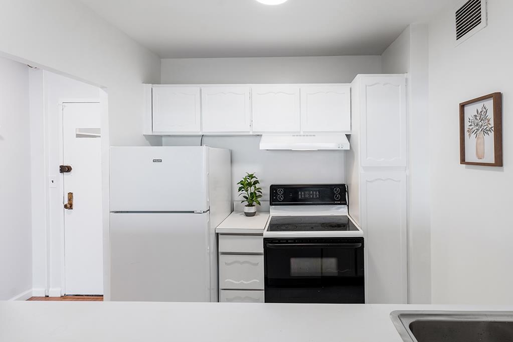 380 Mountain Road, Unit 907 Union City, NJ 07087 - Photo 11 of 25 a kitchen with a refrigerator stove and white cabinets