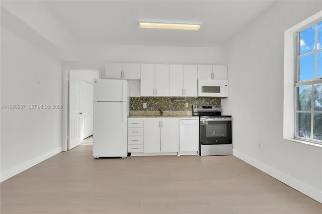 a kitchen with stainless steel appliances white cabinets and a refrigerator