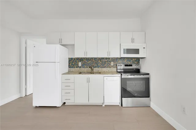 a kitchen with white cabinets and white appliances