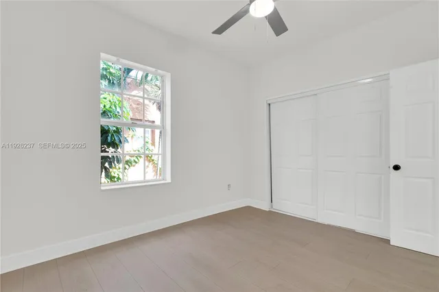 an empty room with windows and closet