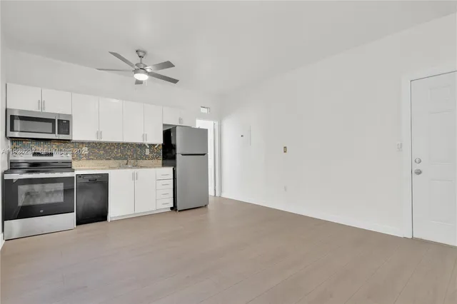 a kitchen with stainless steel appliances a refrigerator and a stove top oven