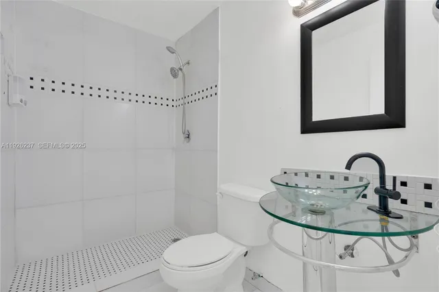 a bathroom with a sink a toilet and shower