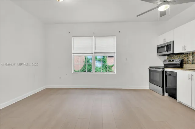 an empty room with windows and a fireplace