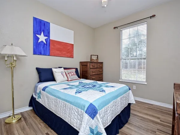 a bedroom with bed and wooden floor