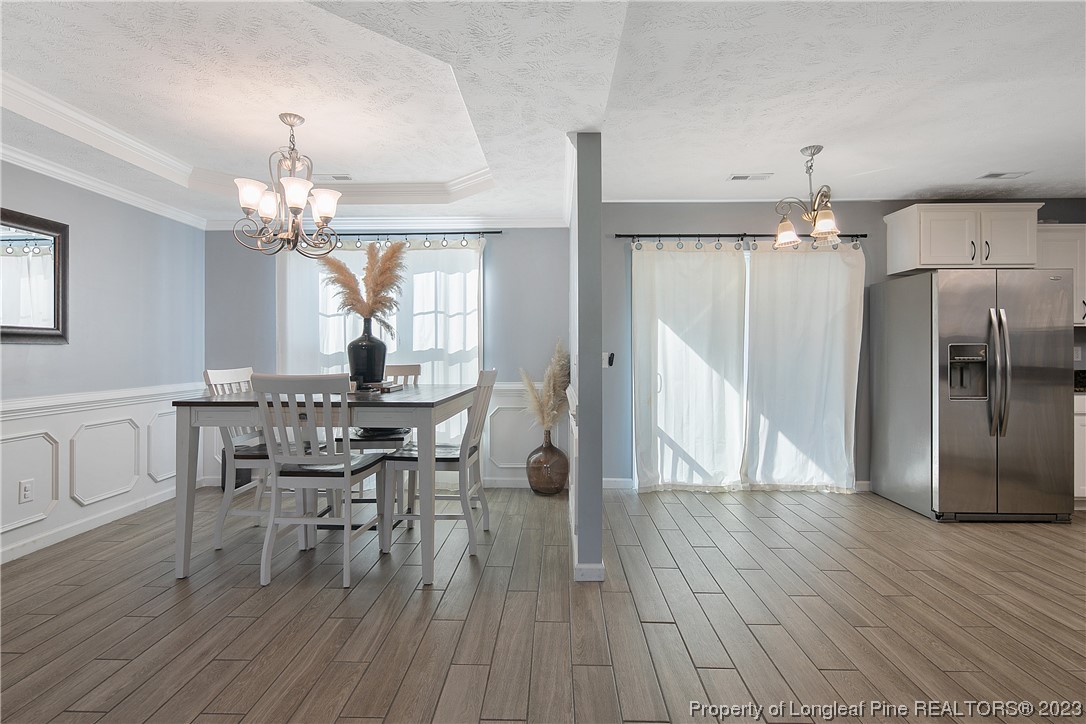 244 Rockingham Street Spring Lake, NC 28390 - Photo 13 of 34 a dining room with furniture a chandelier and wooden floor