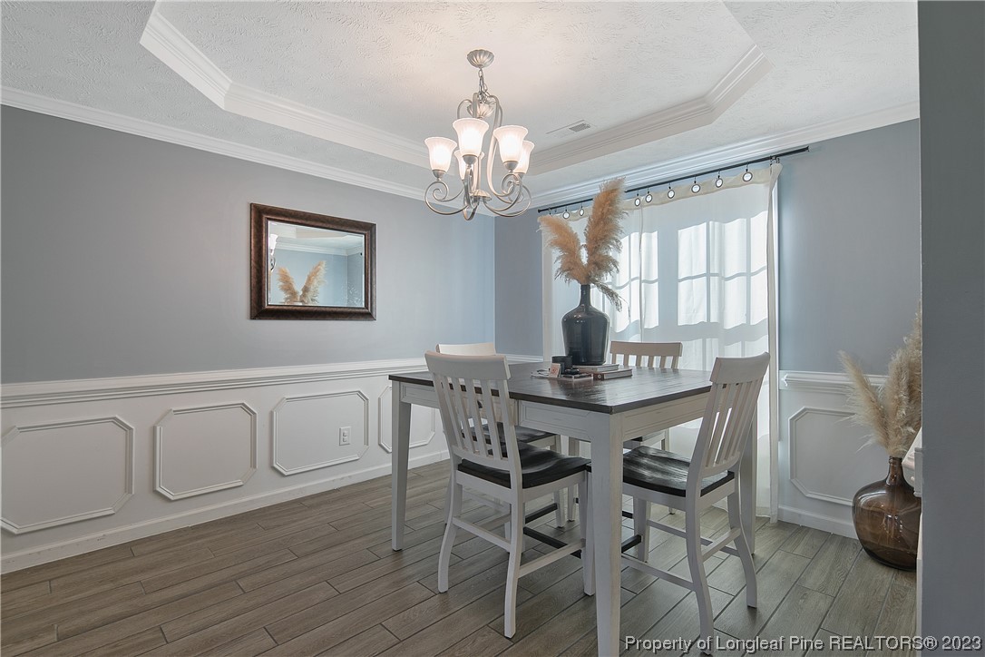 244 Rockingham Street Spring Lake, NC 28390 - Photo 14 of 34 a view of a dining room with furniture a chandelier and wooden floor