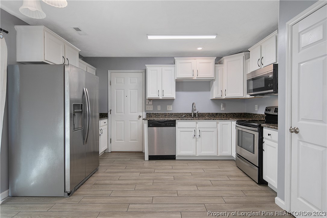 244 Rockingham Street Spring Lake, NC 28390 - Photo 16 of 34 a kitchen with stainless steel appliances granite countertop a refrigerator and a stove top oven