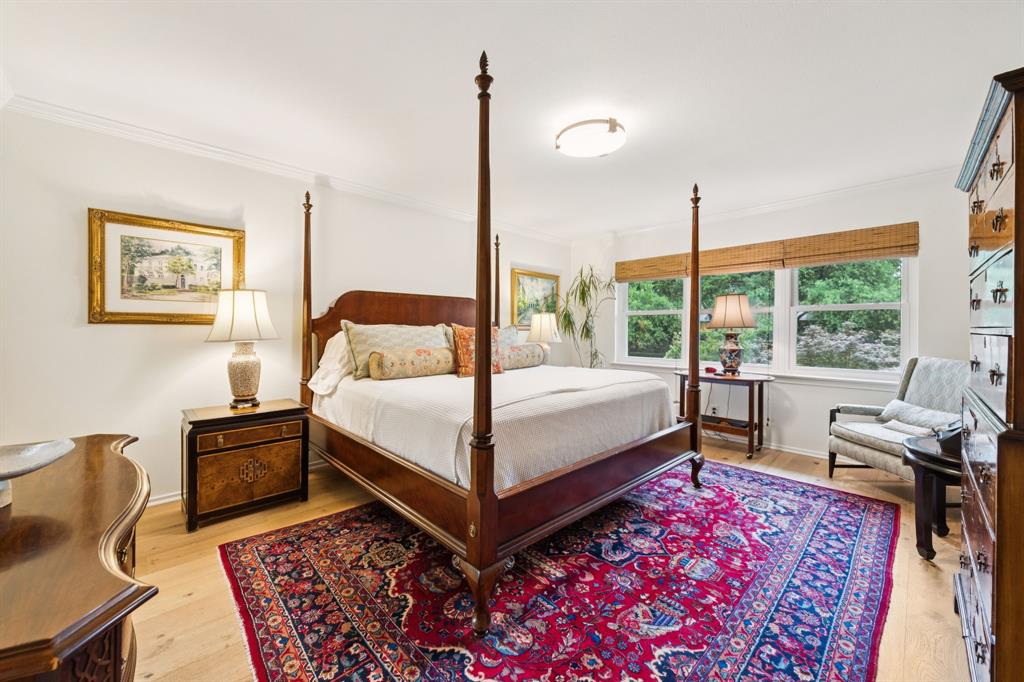 a bedroom with a bed wooden floor and window
