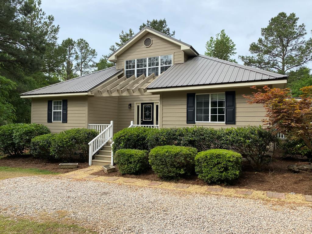 a front view of a house with a yard and potted plants