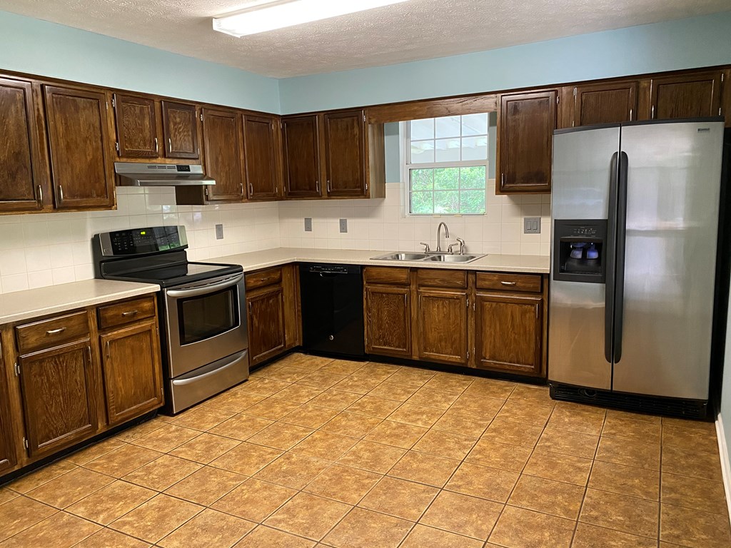 501 Hardy Road LaGrange, GA 30241 - Photo 21 of 37 a kitchen with stainless steel appliances granite countertop a stove a sink dishwasher and a refrigerator